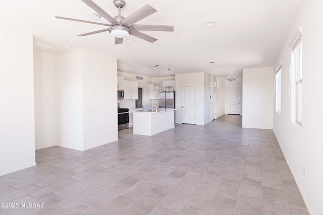 unfurnished living room with ceiling fan with notable chandelier