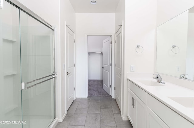 bathroom featuring tile patterned floors, an enclosed shower, and vanity