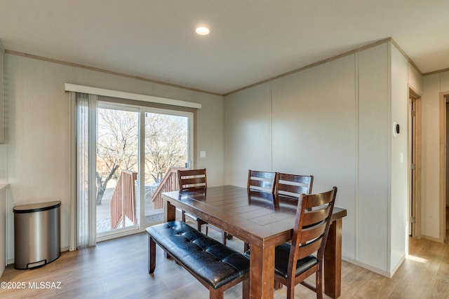 dining space featuring light hardwood / wood-style flooring and ornamental molding