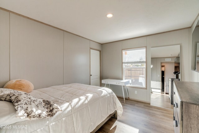 bedroom featuring ornamental molding and light hardwood / wood-style flooring