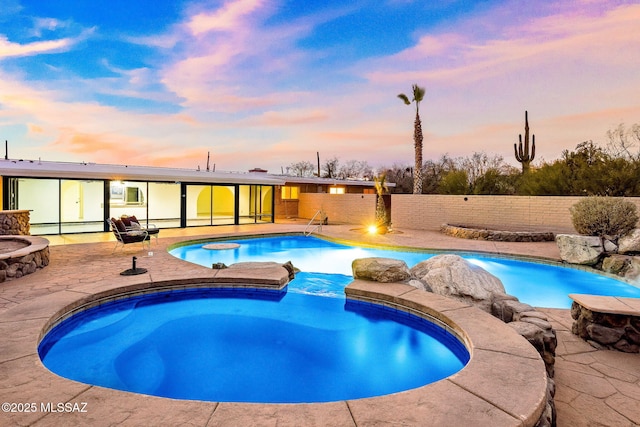 pool at dusk with a patio area