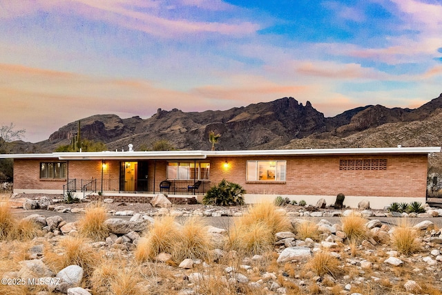 back house at dusk with a mountain view