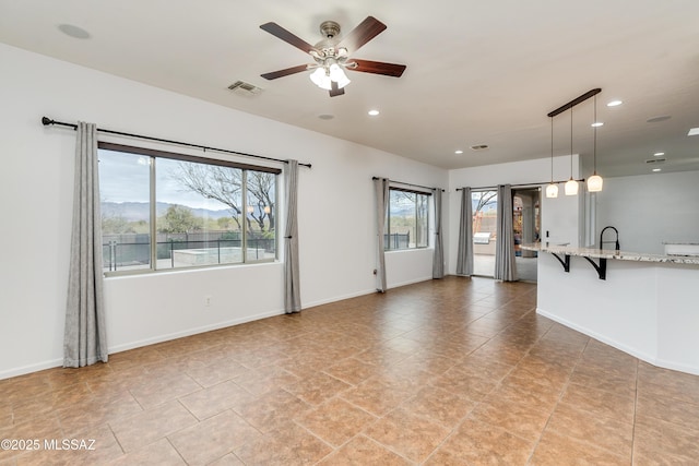 unfurnished living room with baseboards, visible vents, a ceiling fan, and recessed lighting