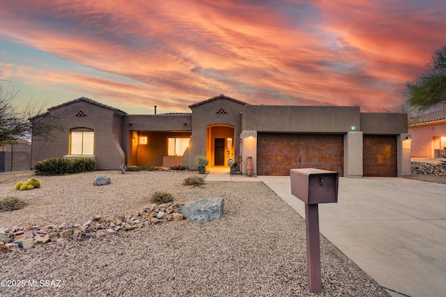 mediterranean / spanish-style home with driveway, an attached garage, and stucco siding