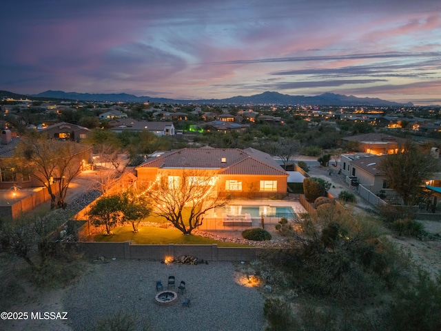 view of front of home featuring a fenced backyard, a mountain view, and a tiled roof