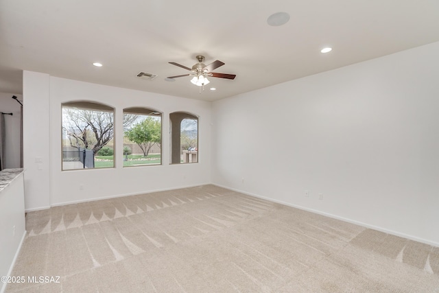 empty room featuring ceiling fan, recessed lighting, light carpet, visible vents, and baseboards