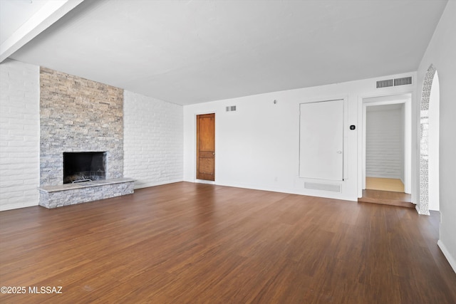 unfurnished living room with visible vents, a fireplace, and wood finished floors