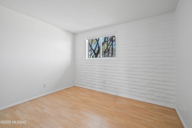 spare room featuring wood finished floors and baseboards