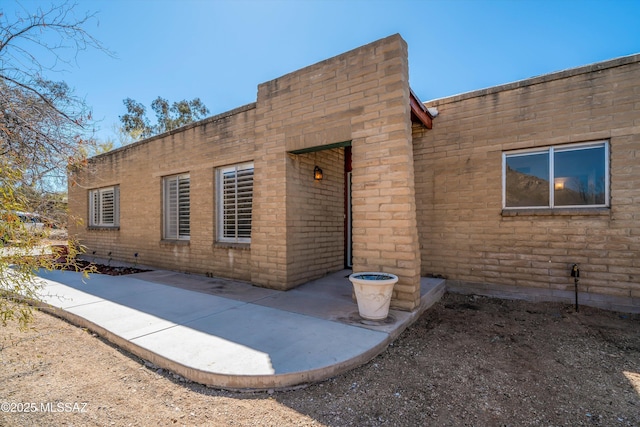 rear view of property with a patio area and brick siding