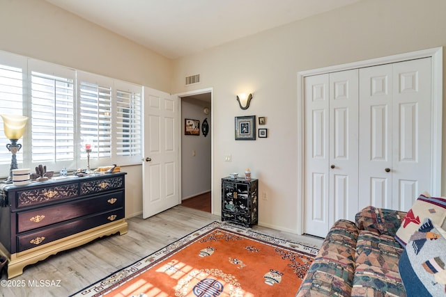 interior space with a closet, wood finished floors, visible vents, and baseboards