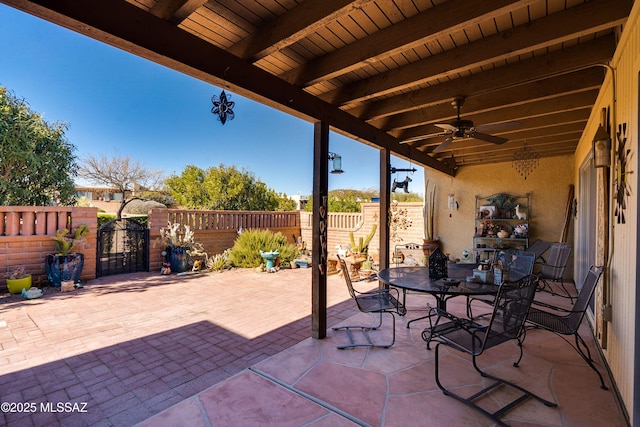 view of patio with fence private yard, ceiling fan, a gate, and outdoor dining area