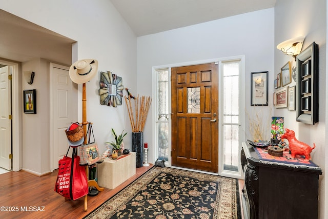 entryway with vaulted ceiling and wood finished floors