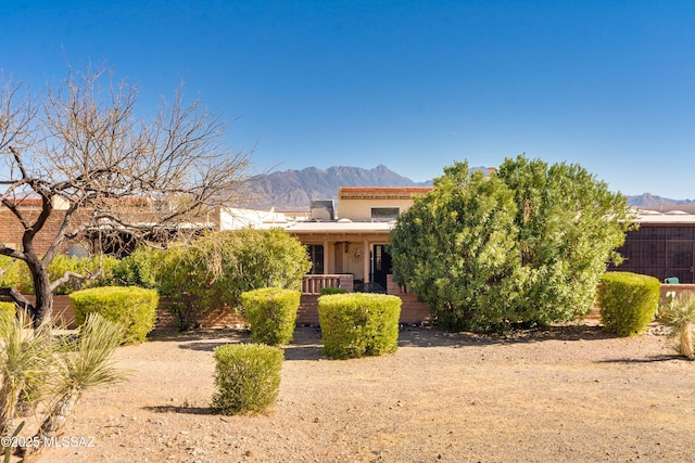 view of front of home with covered porch, a mountain view, and stucco siding