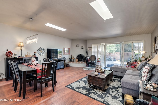 living room with a skylight, a textured ceiling, and wood finished floors