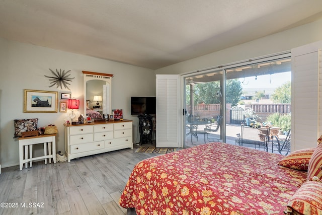 bedroom featuring access to exterior and wood finished floors