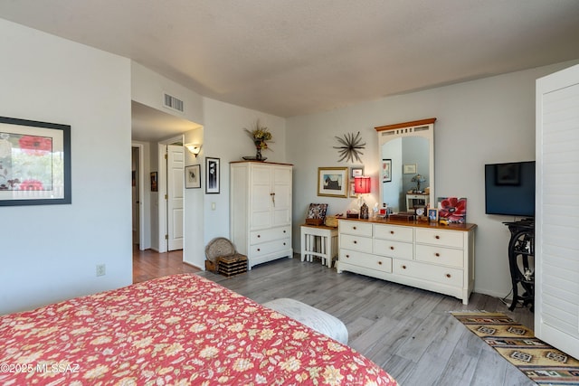 bedroom featuring a textured ceiling, wood finished floors, and visible vents