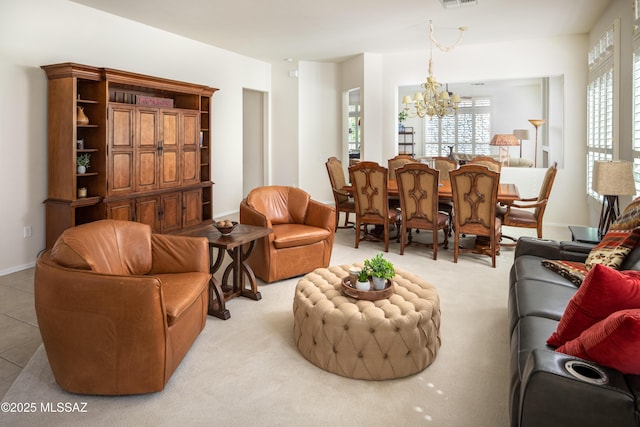 living room with light tile patterned floors, visible vents, baseboards, and an inviting chandelier