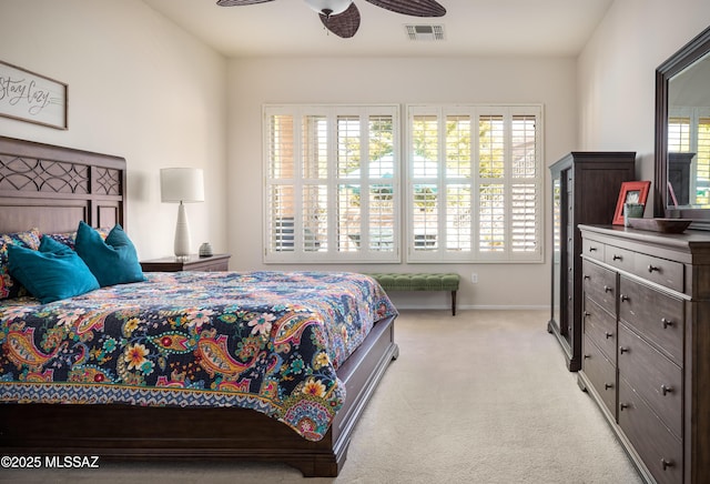 bedroom featuring a ceiling fan, visible vents, light carpet, and baseboards