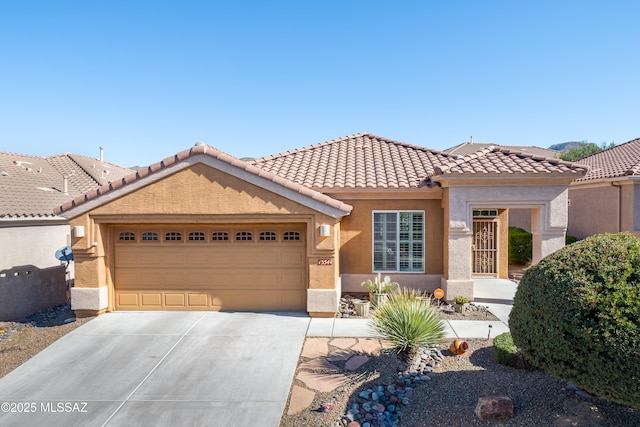 view of front facade featuring a garage, a tile roof, concrete driveway, and stucco siding