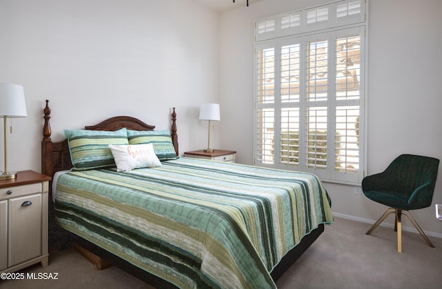 carpeted bedroom featuring multiple windows and baseboards