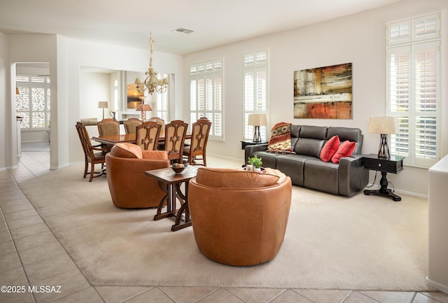 carpeted living room with baseboards, visible vents, a chandelier, and a wealth of natural light