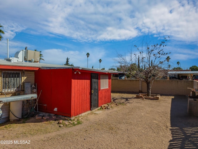 view of outbuilding with fence and an outbuilding