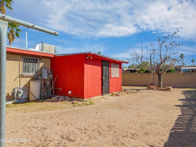 view of outdoor structure featuring fence and an outbuilding