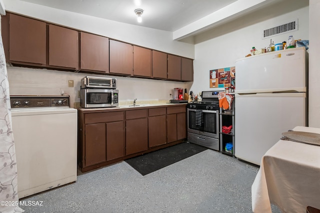 kitchen with stainless steel appliances, a sink, visible vents, dark brown cabinets, and washer / dryer