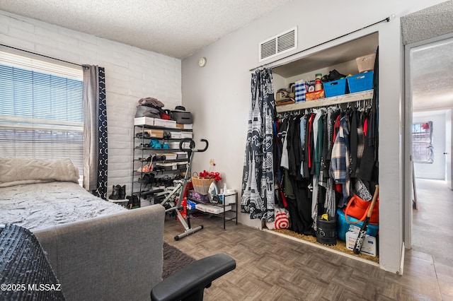 bedroom with a closet, visible vents, and a textured ceiling