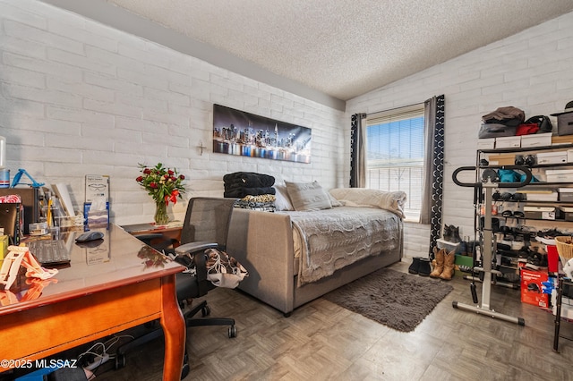 bedroom featuring a textured ceiling, brick wall, and lofted ceiling