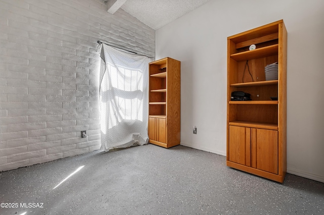 spare room with lofted ceiling with beams, a textured ceiling, and speckled floor