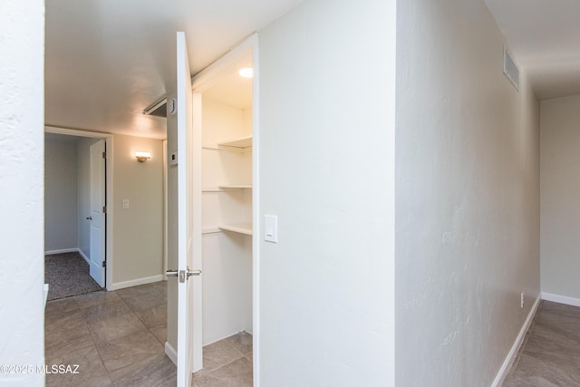 corridor featuring baseboards and visible vents