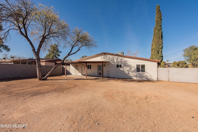 back of property featuring a patio area and fence