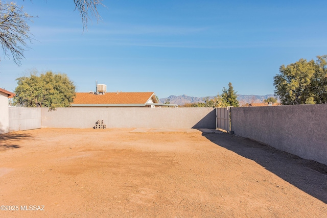 view of yard with a fenced backyard and a mountain view