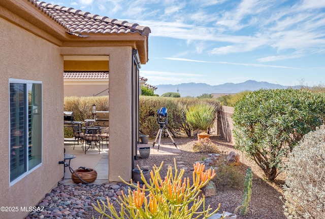 view of patio / terrace with a fenced backyard, a mountain view, and a grill