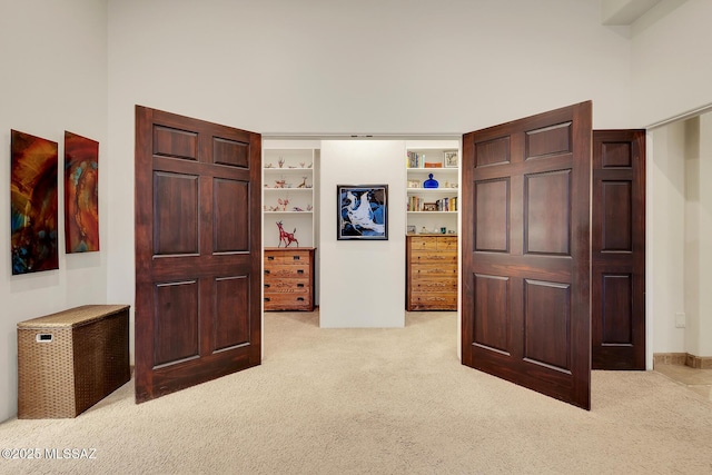 interior space with a high ceiling and light colored carpet