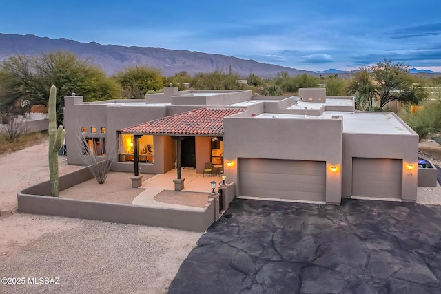 pueblo revival-style home featuring a garage and a mountain view