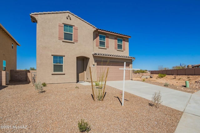 view of front of property featuring concrete driveway, fence, a tiled roof, and stucco siding