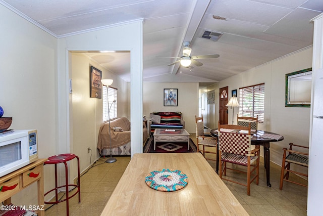 dining space featuring crown molding, ceiling fan, and lofted ceiling with beams