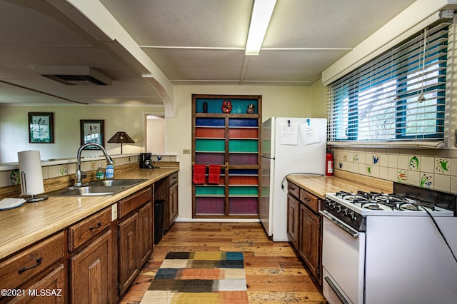 kitchen with dark hardwood / wood-style flooring, sink, white appliances, and backsplash