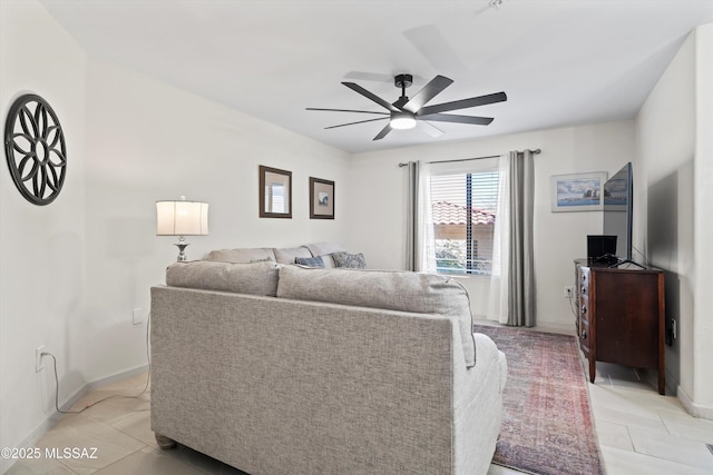 living room with ceiling fan, light tile patterned floors, and baseboards