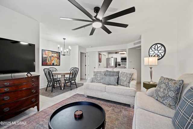 living area with light tile patterned floors, visible vents, and ceiling fan with notable chandelier