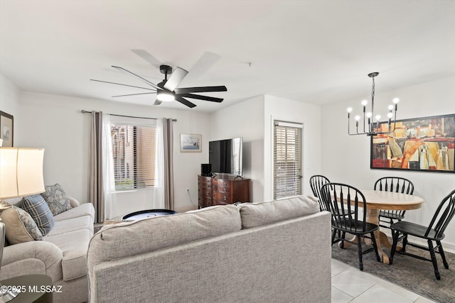 living room with ceiling fan with notable chandelier and light tile patterned floors