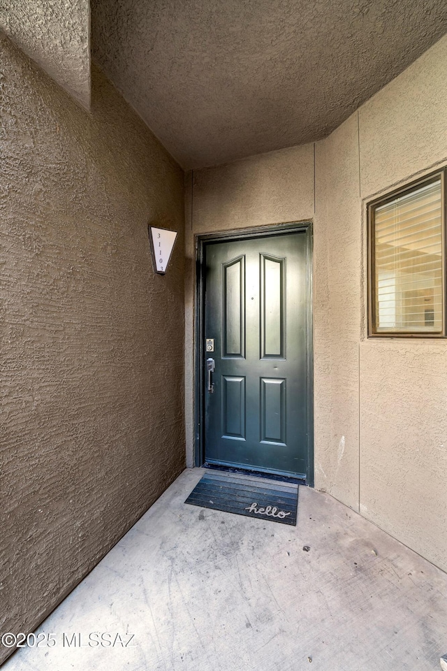 view of exterior entry featuring stucco siding