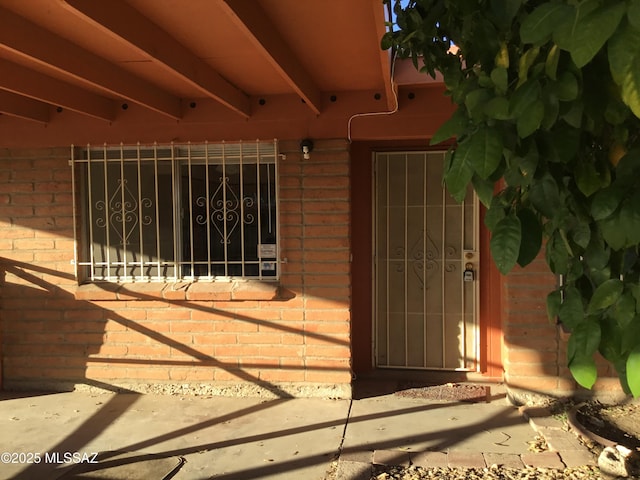 entrance to property featuring brick siding