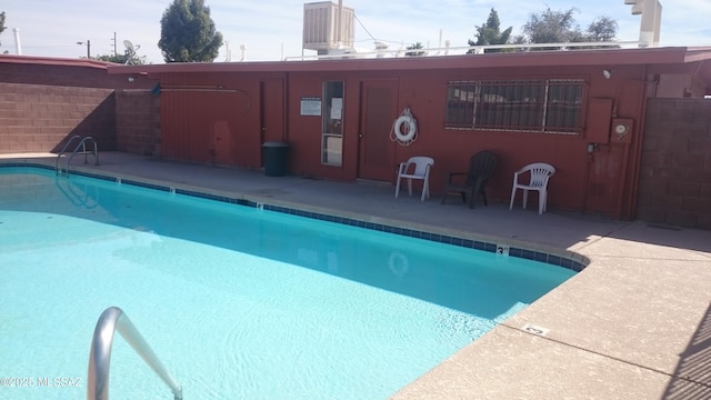 community pool featuring a patio and cooling unit