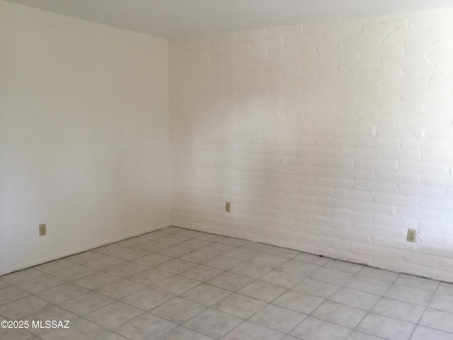 empty room featuring brick wall