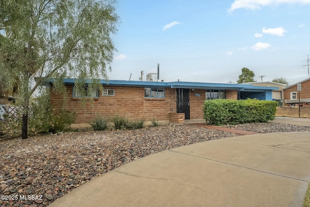 ranch-style house featuring brick siding