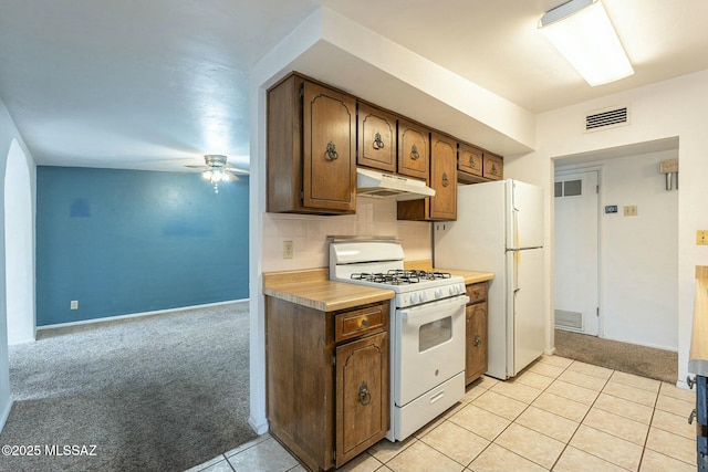 kitchen featuring white appliances, light colored carpet, visible vents, and under cabinet range hood