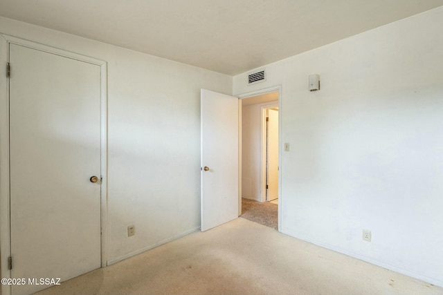 unfurnished bedroom featuring visible vents and light colored carpet